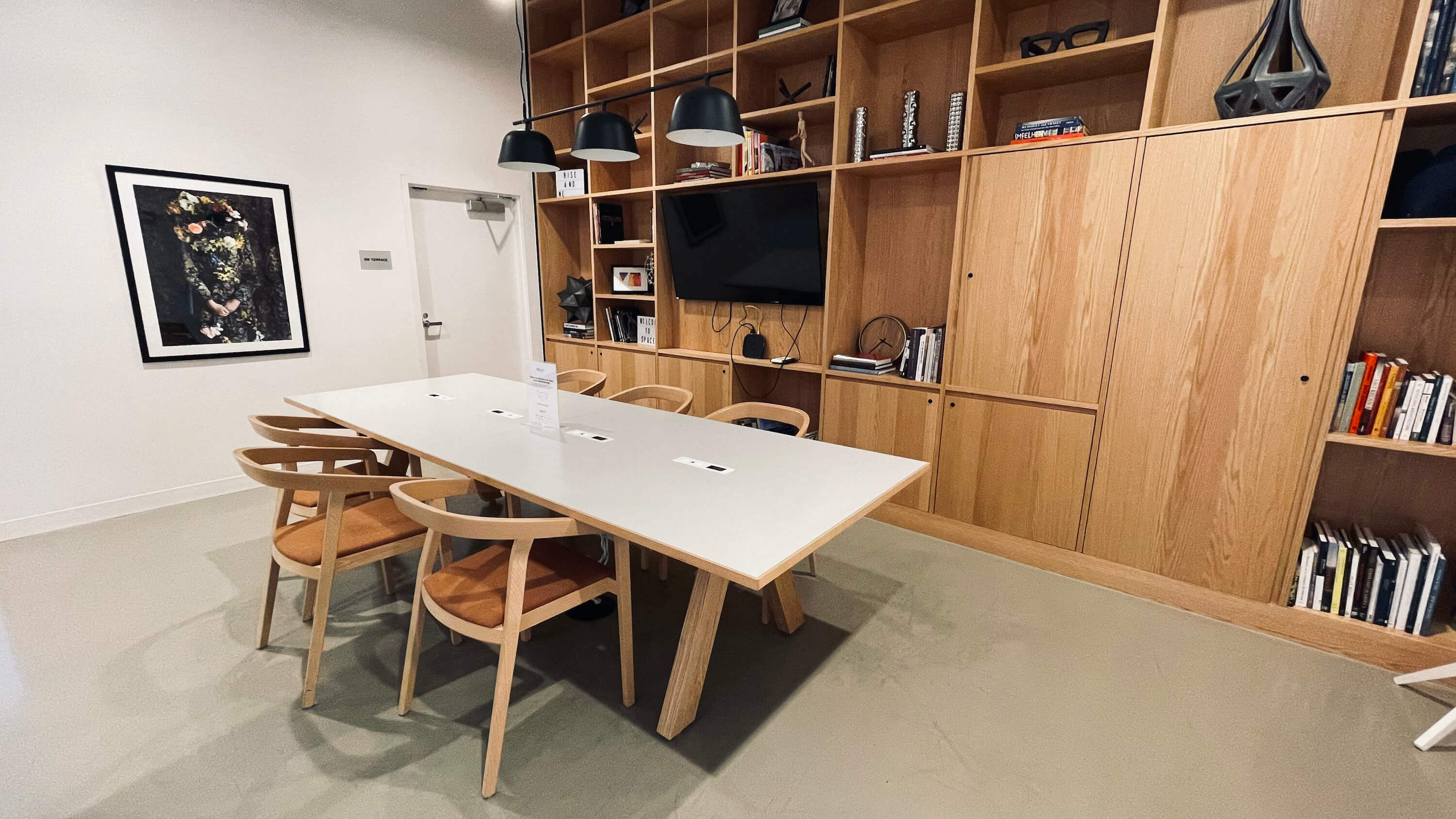 Private conference room on the Main Floor at 1800 Vine St with long table and bookshelf wall