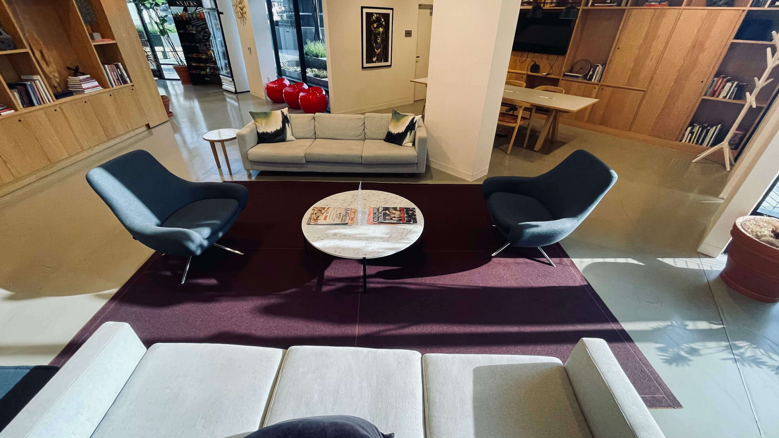 Lounge seating area on the Main Floor at 1800 Vine St with sofas, marble coffee table, and natural light