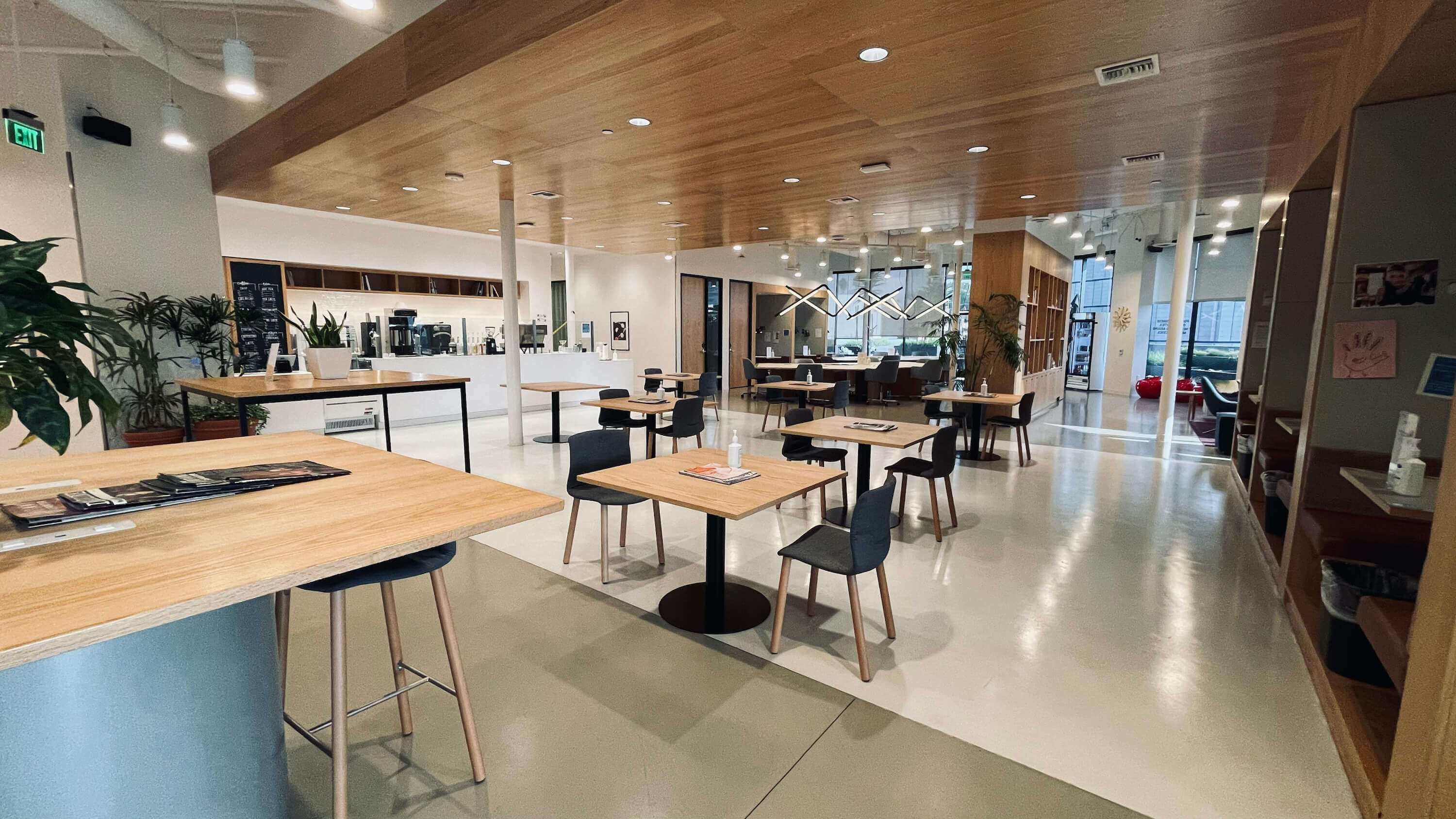 Main Floor at 1800 Vine St showing open common area with wooden tables, service bar, and wood-paneled ceiling