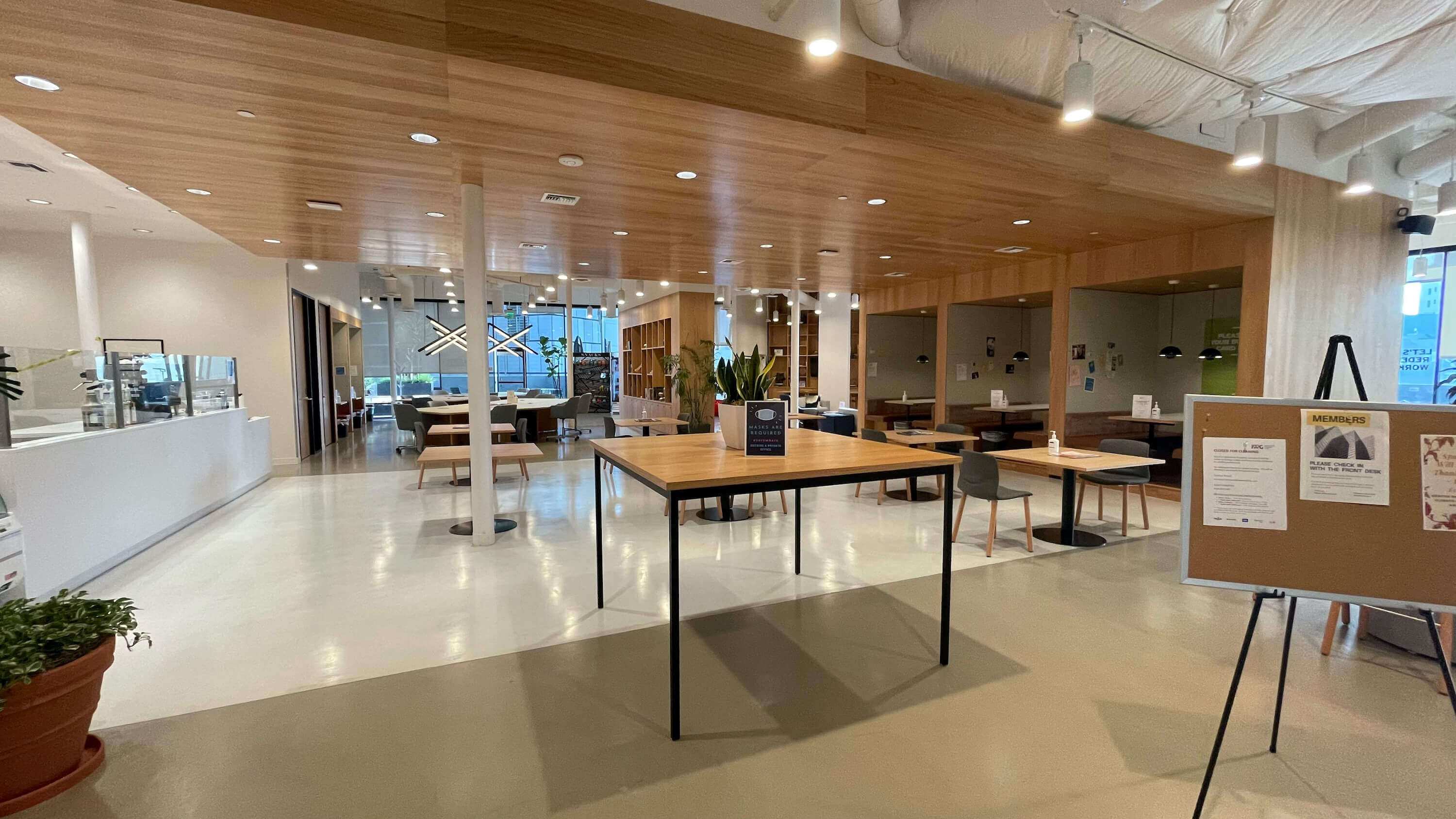 Open floor area on the Main Floor at 1800 Vine St with tables, columns, and glass-walled meeting rooms