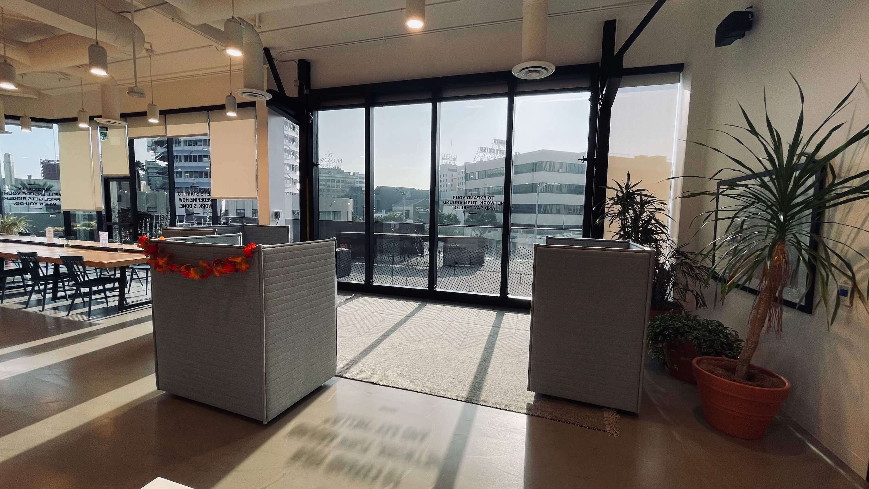 High-backed chairs at floor-to-ceiling windows on the Main Floor at 1800 Vine St with city views