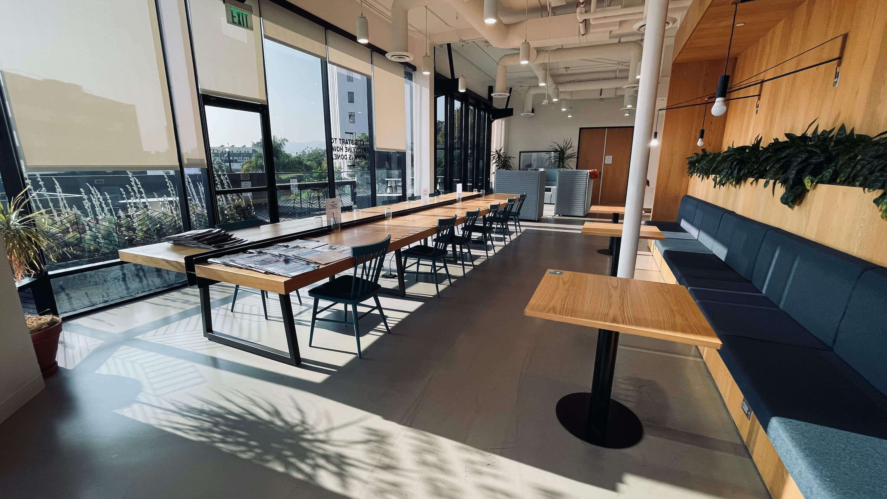 Long communal table along the window wall at 1800 Vine St Main Floor with dramatic natural light