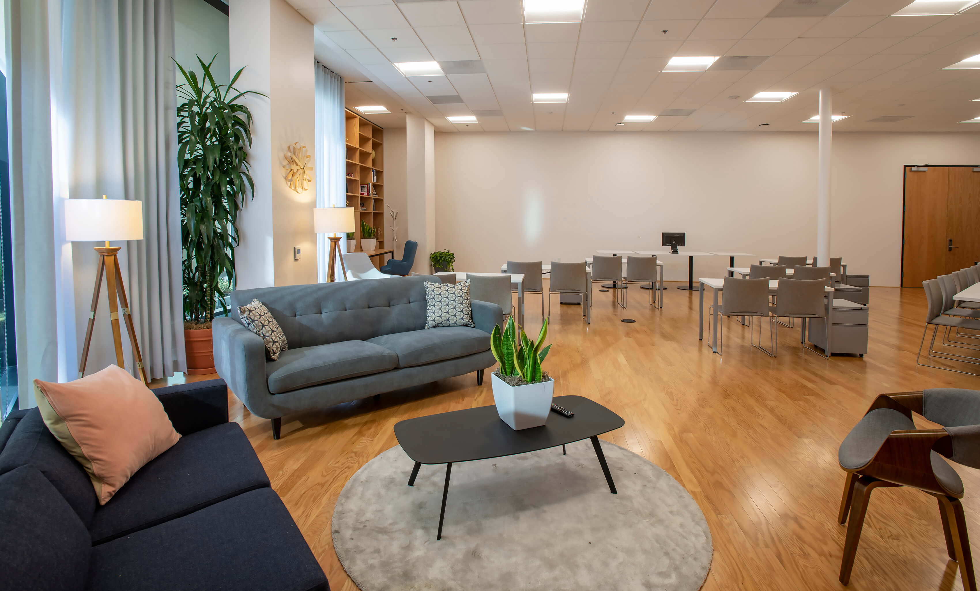 Lounge seating area in the Meeting Hall at 1800 Vine St with sofas, coffee table, and plants