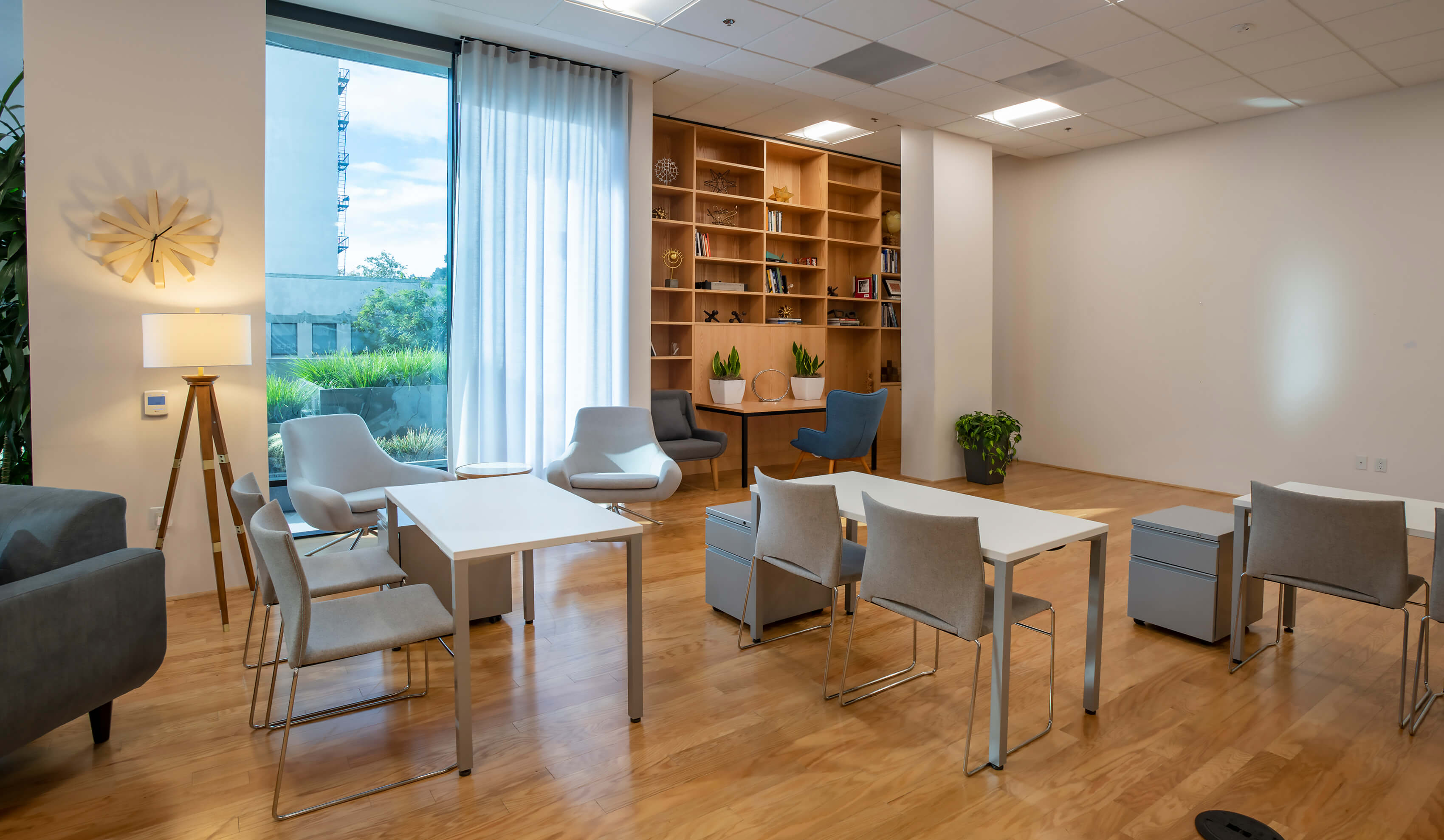 Window detail in the Meeting Hall at 1800 Vine St showing natural light, armchairs, and bookshelves