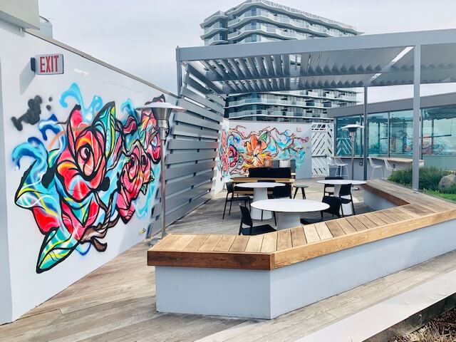 Rose mural seating nook with built-in bench at 1800 Vine St rooftop