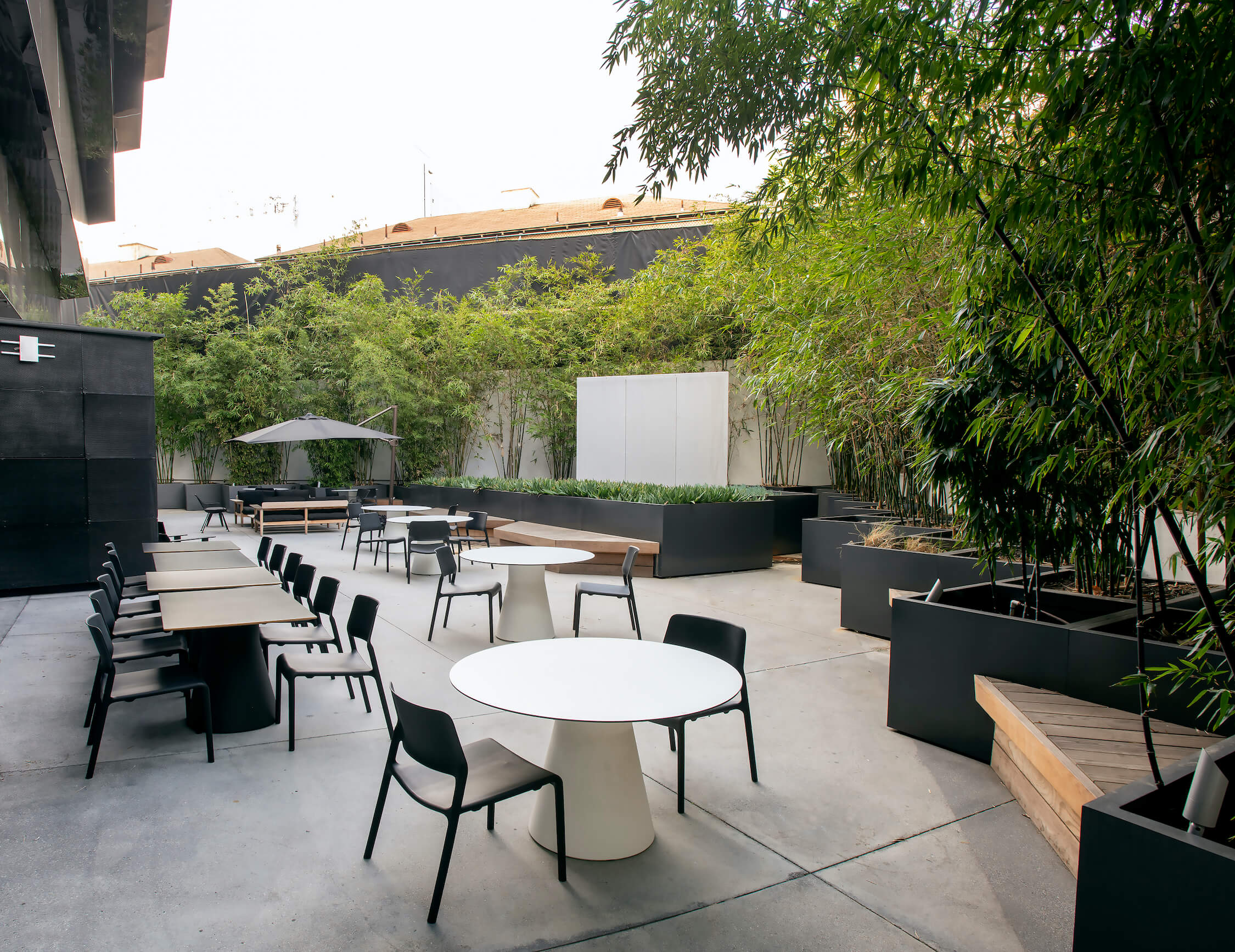 Daytime wide view of the Vine St. Patio showing communal and round tables at 1800 Vine St